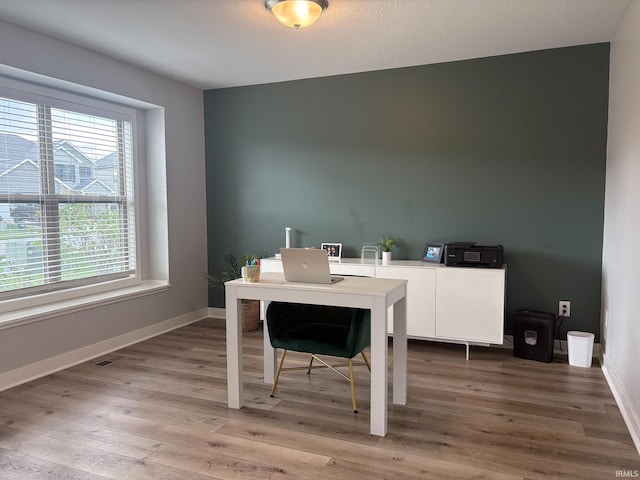 office area with baseboards and light wood finished floors