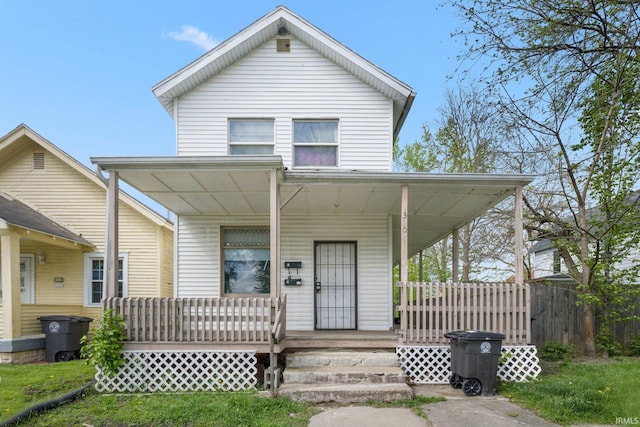 view of front of property featuring a porch and fence