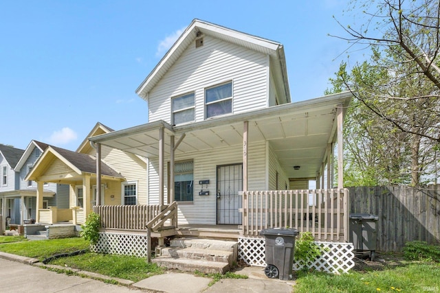 view of front of house with a porch and fence