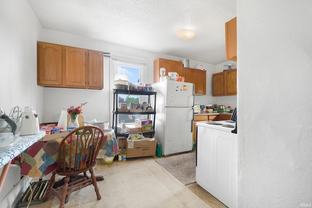 kitchen with brown cabinetry, freestanding refrigerator, light countertops, a textured ceiling, and electric stove