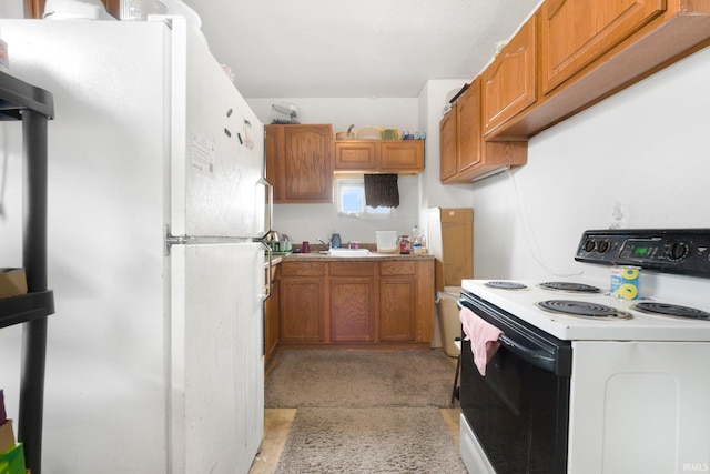 kitchen with white appliances, brown cabinets, a sink, and light countertops