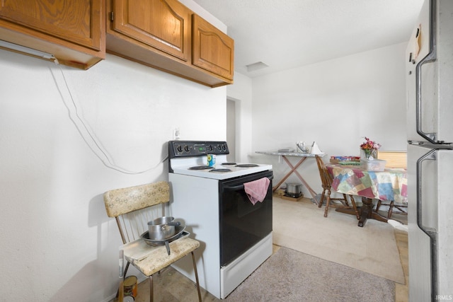 kitchen with light countertops, light carpet, brown cabinets, and white appliances