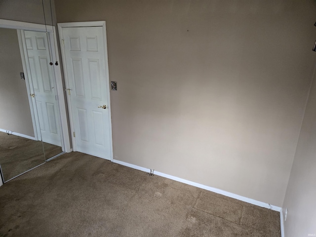 unfurnished room with baseboards and carpet