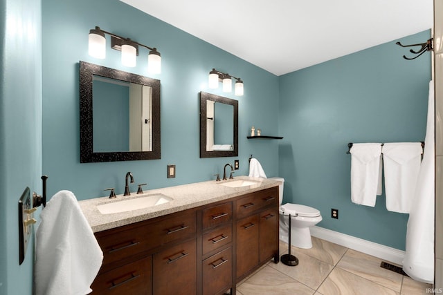 1206 Phaeton Way, Auburn, IN 46706 - bathroom with toilet, double vanity, baseboards, and a sink