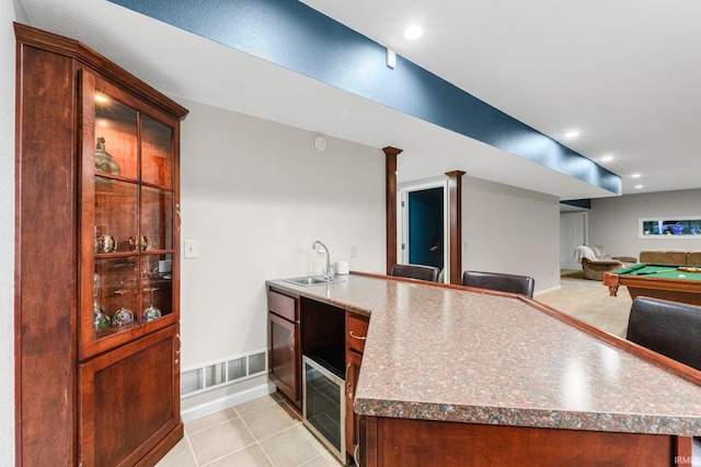 1206 Phaeton Way, Auburn, IN 46706 - kitchen with a sink, a peninsula, baseboards, open floor plan, and light tile patterned floors