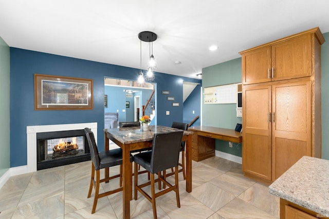 1206 Phaeton Way, Auburn, IN 46706 - dining space with baseboards, stairs, and a multi sided fireplace
