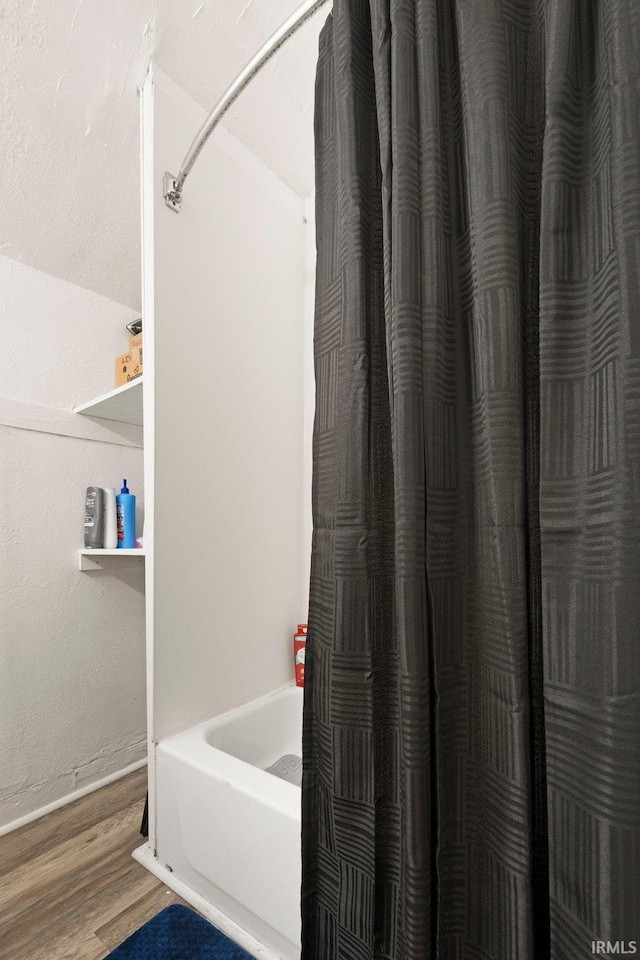 full bathroom with shower / bathtub combination with curtain and wood finished floors