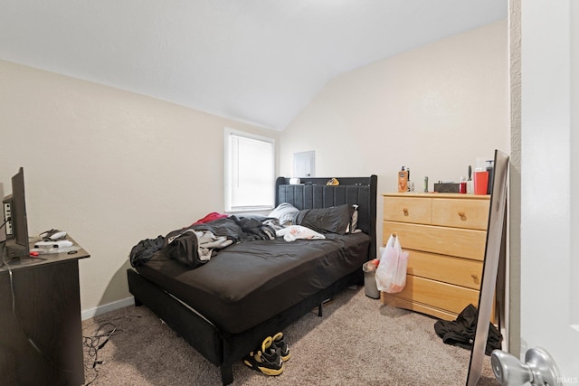 carpeted bedroom featuring baseboards and vaulted ceiling