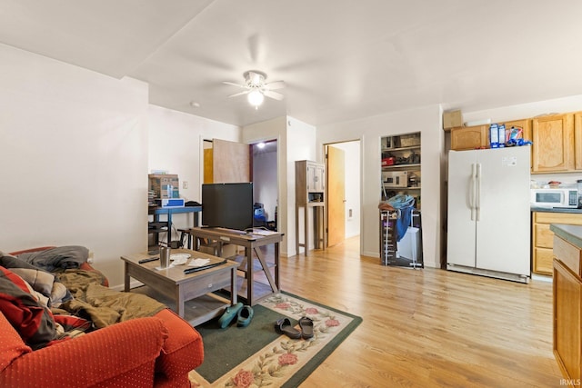 living area with ceiling fan and light wood-style flooring