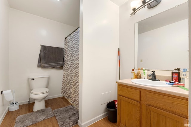 full bathroom featuring vanity, baseboards, toilet, and wood finished floors