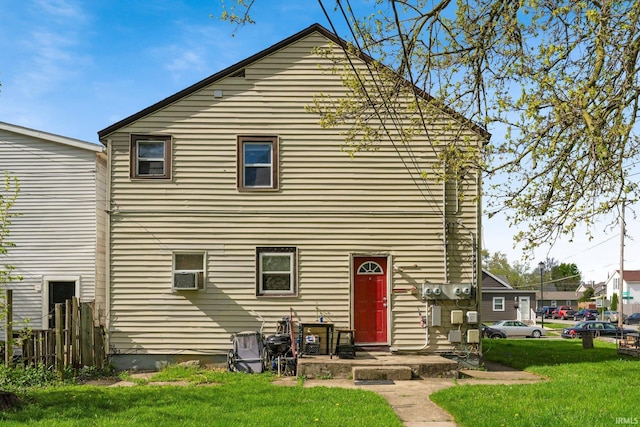 rear view of house with a yard and cooling unit