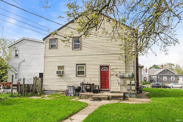 rear view of house featuring a yard, fence, and cooling unit