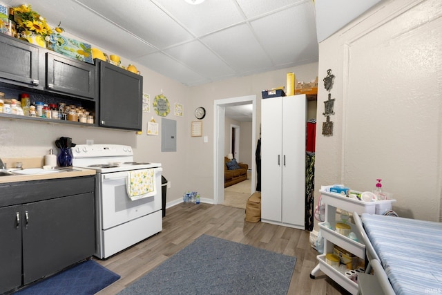kitchen featuring electric panel, white electric stove, open shelves, a sink, and light wood finished floors