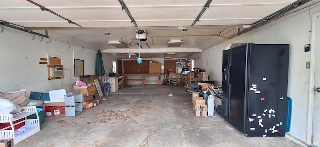 garage featuring black fridge and a garage door opener