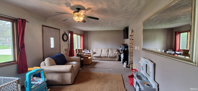 carpeted living area featuring a textured ceiling and ceiling fan