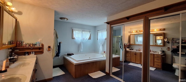 bathroom featuring double vanity, a jetted tub, a textured ceiling, a sink, and a stall shower