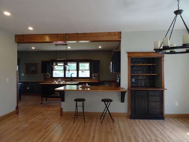 kitchen featuring recessed lighting, range, a kitchen breakfast bar, and light wood-style flooring