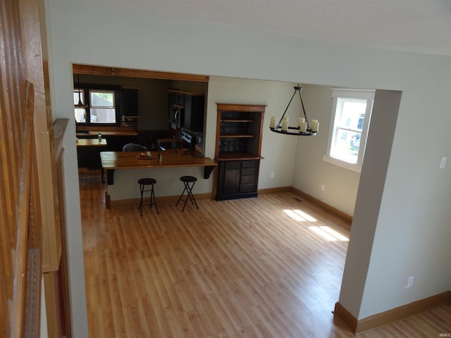 dining room with baseboards, wood finished floors, and a healthy amount of sunlight