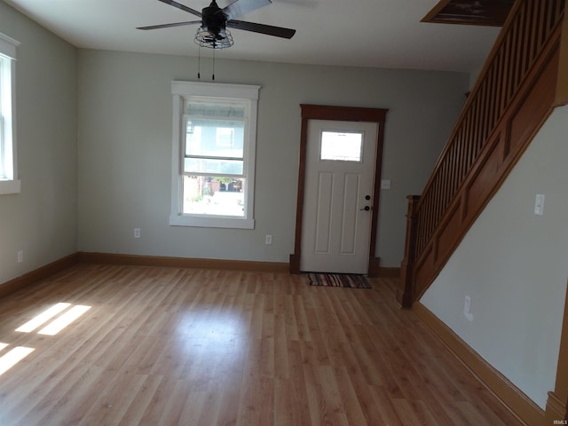 entrance foyer featuring stairs, ceiling fan, baseboards, and light wood finished floors