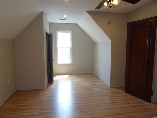 bonus room featuring visible vents, a ceiling fan, light wood finished floors, and vaulted ceiling