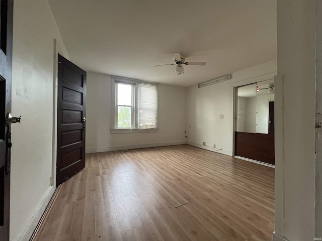 unfurnished bedroom featuring a ceiling fan, baseboards, and light wood finished floors