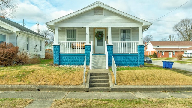 view of front of house featuring covered porch and a front yard