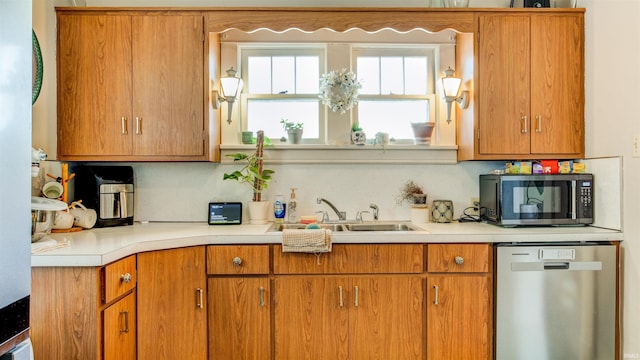kitchen featuring a sink, light countertops, brown cabinetry, and stainless steel appliances