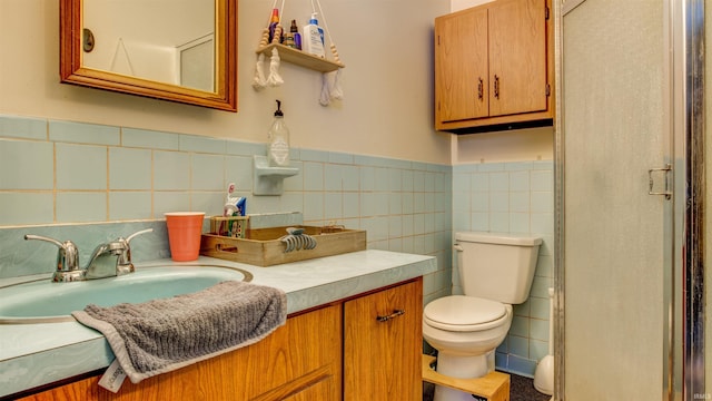 bathroom featuring tile walls, a wainscoted wall, vanity, and toilet