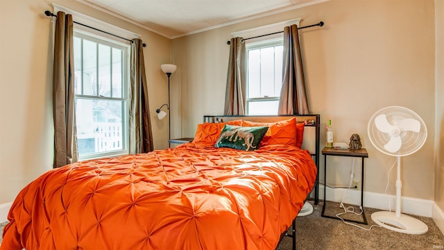 bedroom featuring crown molding, baseboards, carpet floors, and multiple windows