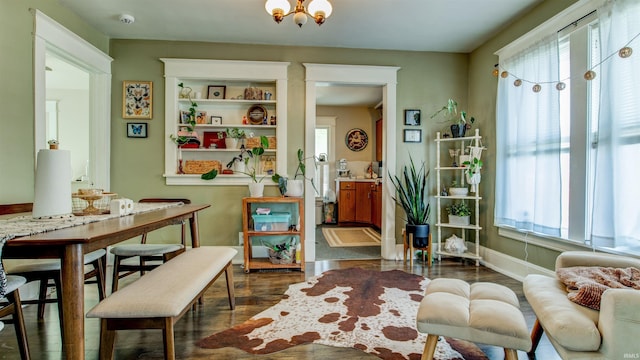 living area with baseboards and dark wood-type flooring