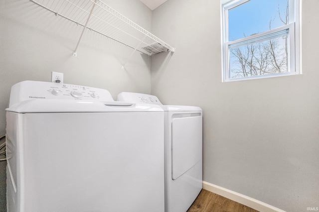 laundry room with baseboards, laundry area, washing machine and dryer, and wood finished floors