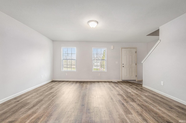 unfurnished living room featuring baseboards and wood finished floors