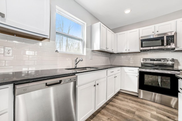 kitchen featuring a sink, white cabinetry, appliances with stainless steel finishes, and dark countertops