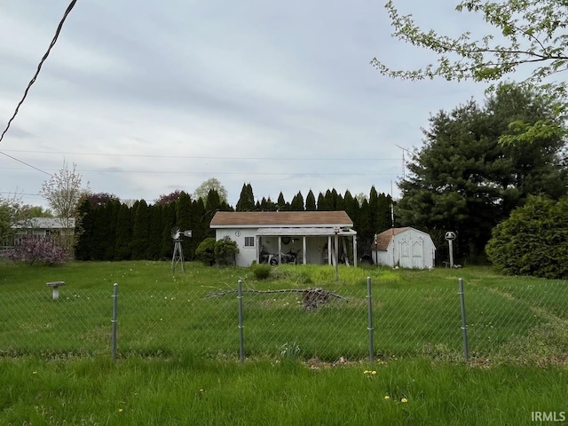 view of front of property with a front lawn, fence, an outbuilding, and a shed