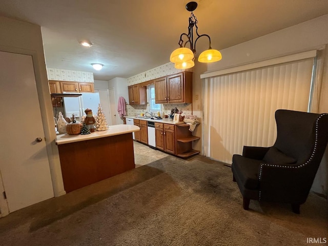 kitchen featuring hanging light fixtures, light colored carpet, white appliances, light countertops, and brown cabinetry