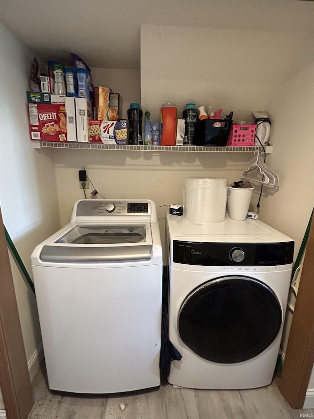 laundry room featuring light wood-style floors, laundry area, and washer and dryer