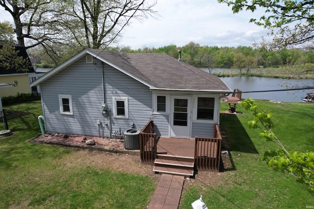 rear view of property with a yard, central AC, a shingled roof, and a deck with water view