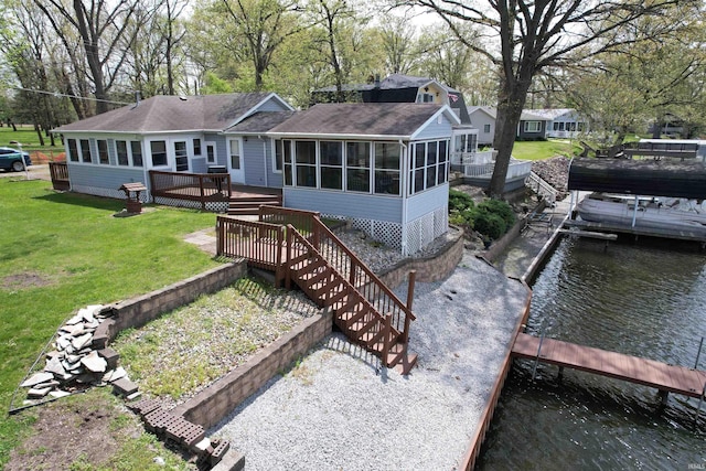 rear view of house featuring a sunroom, roof with shingles, a lawn, and a deck with water view