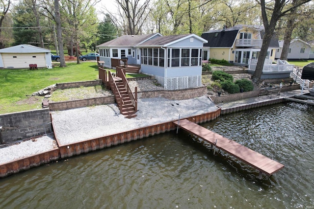 dock area with stairs, a lawn, and a deck with water view