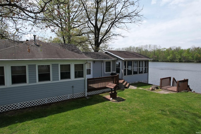 rear view of property with a water view, a yard, roof with shingles, and a sunroom