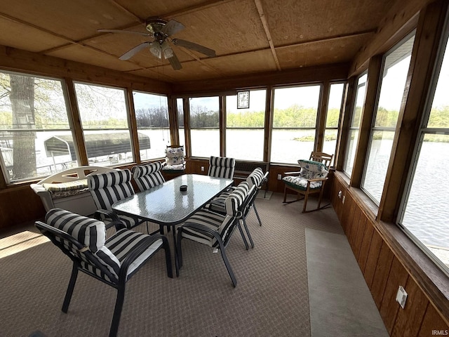 sunroom / solarium with carpet flooring, a wealth of natural light, and a water view