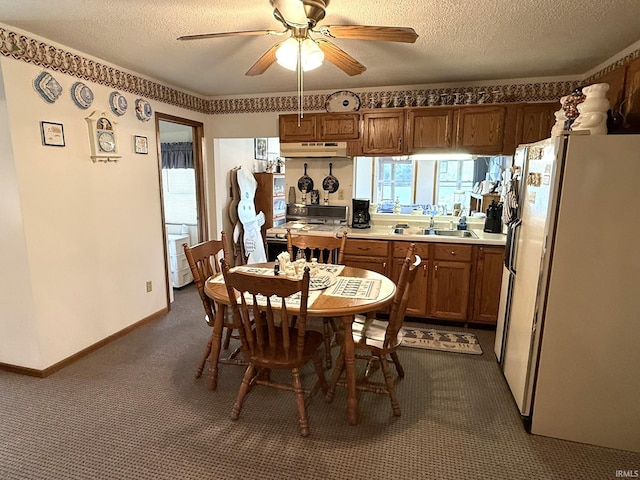dining space with a textured ceiling, baseboards, a ceiling fan, and dark carpet
