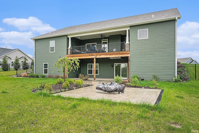 rear view of property with a patio, a ceiling fan, a yard, and a balcony
