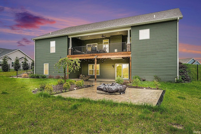 back of property with a yard, ceiling fan, a balcony, and a patio area