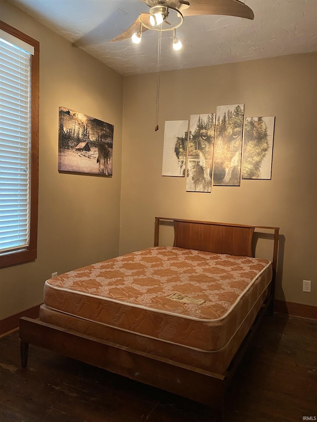 bedroom with baseboards, a ceiling fan, and wood finished floors