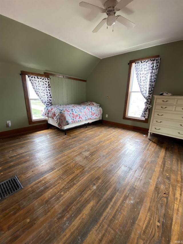 bedroom featuring wood-type flooring, vaulted ceiling, multiple windows, and visible vents