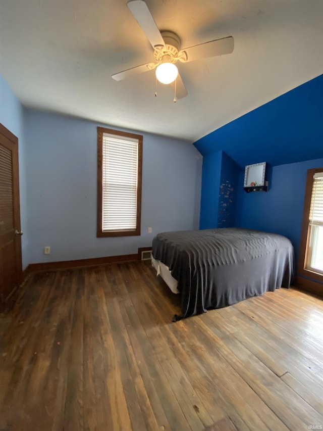 bedroom featuring wood-type flooring, a ceiling fan, baseboards, and visible vents