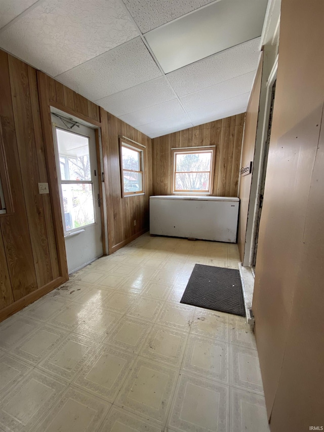 spare room with light floors and wooden walls