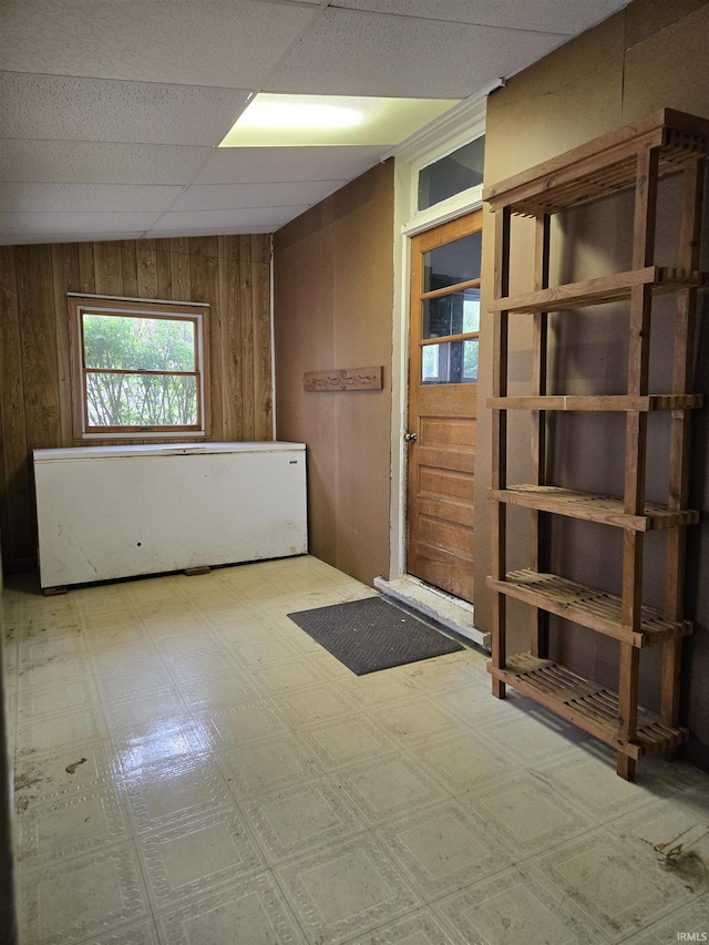 empty room with wooden walls and tile patterned floors
