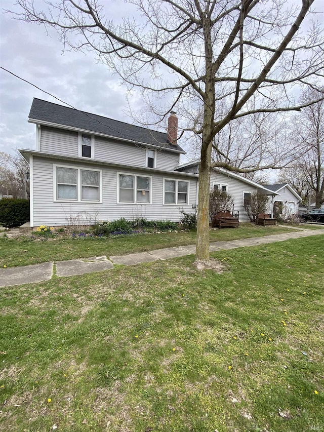 traditional-style house featuring a chimney and a front yard